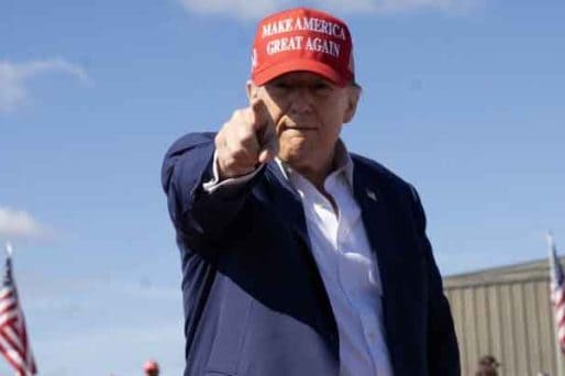 Trump wearing a MAGA hat and pointing at the camera